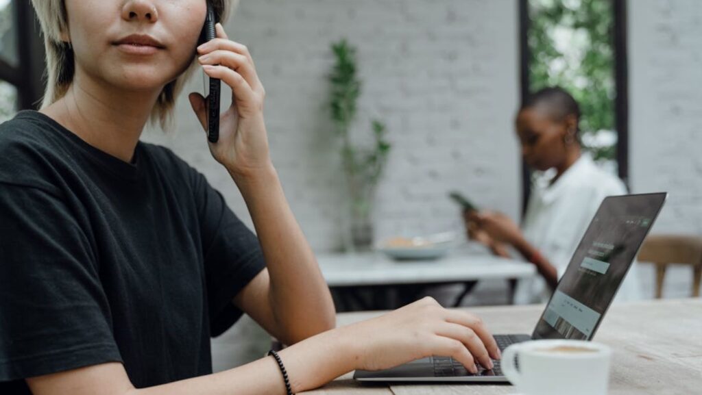 Person in casual wear making phone call in cafe